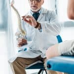 cropped view of man sitting near doctor gesturing while holding